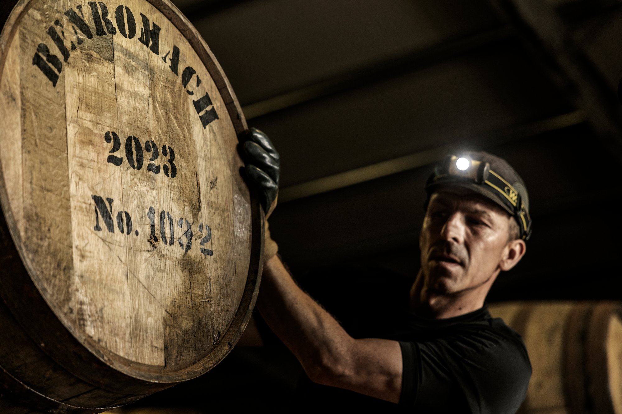 an image of a warehouseman rolling a whisky cask into place in a warehouse