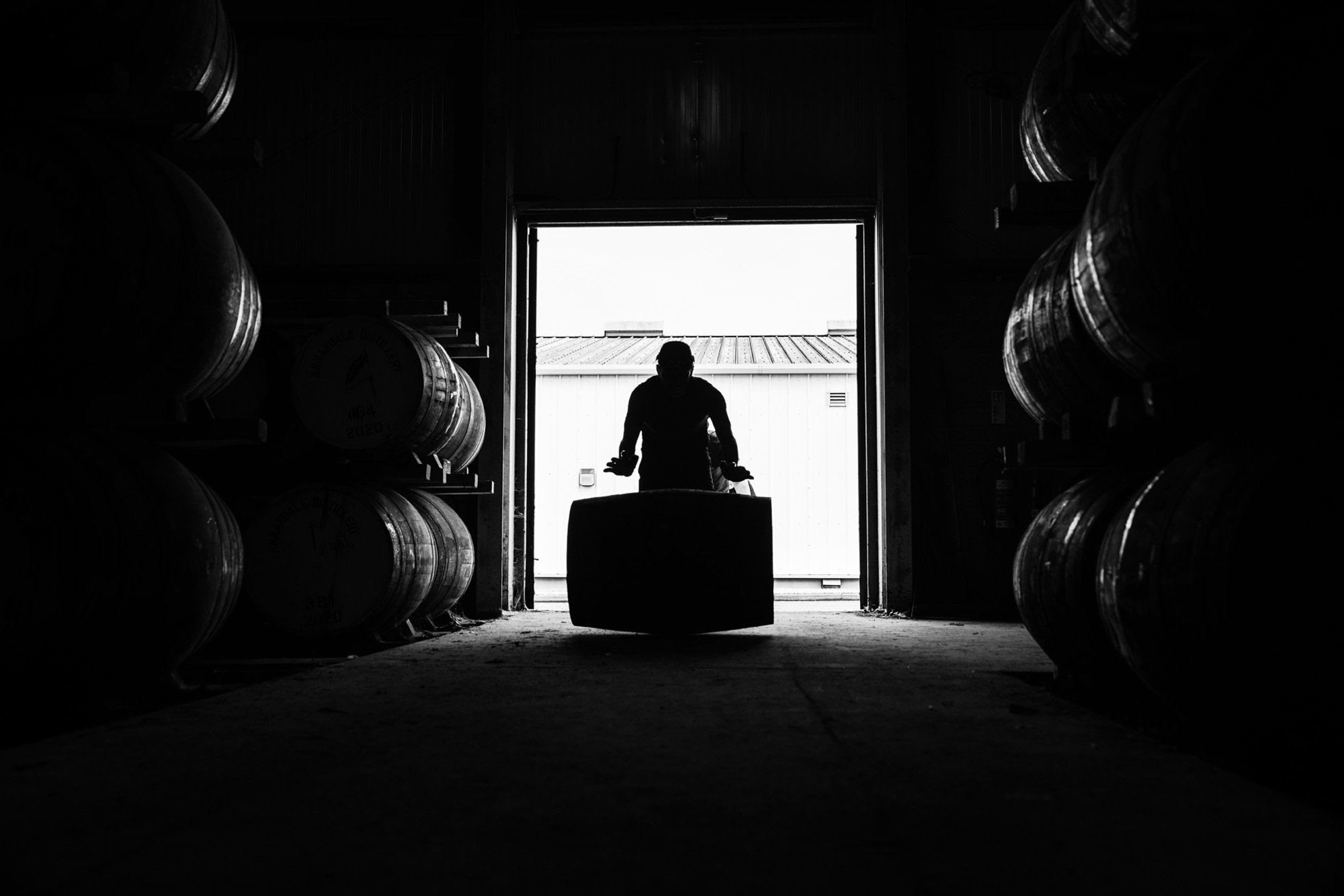 A member of the Benromach warehouse team rolling a cask into the warehouse